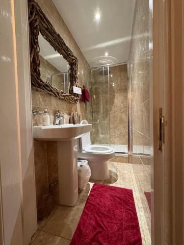 a bathroom with a sink and a toilet and a shower at West Highland Way Hotel in Glasgow