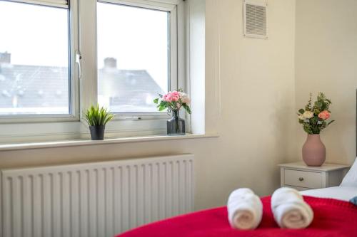 een slaapkamer met een bed en een raam met bloemen bij Modern Wolverhampton 3 bed Home in Wolverhampton
