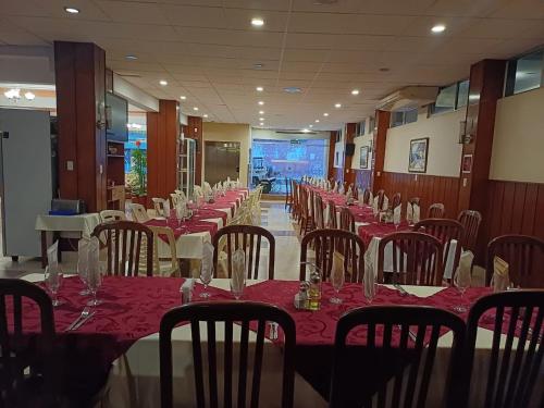ein Esszimmer mit Tischen, Stühlen und roten Tischdecken in der Unterkunft JR HOTEL in Refineria Camiri
