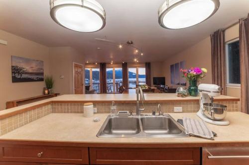 a kitchen with a sink and a counter with windows at Family Getaway in Juneau Unforgettable Ocean Views in Mendenhaven