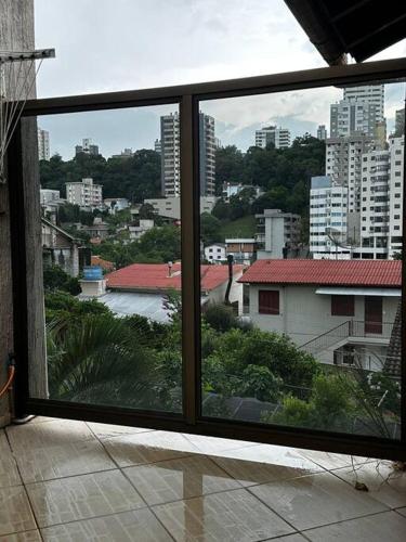a view of a city from a large window at apartamento em bairro nobre suíte com ar condicionado e banheira com hidromassagem in Bento Gonçalves