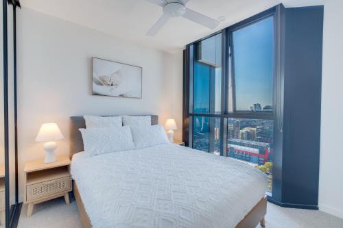 a bedroom with a bed and a large window at 1BR The Coterie Apartments - 1 Bedroom Deluxe Apartmen in Brisbane
