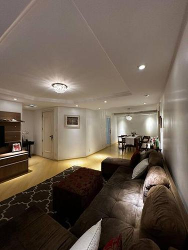a large living room with a couch and a table at apartamento em bairro nobre suíte com ar condicionado e banheira com hidromassagem in Bento Gonçalves