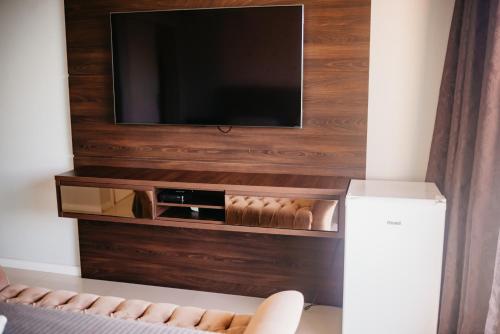 uma sala de estar com televisão na parede em Morada da Lagoinha em Florianópolis