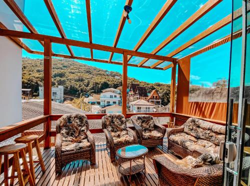 una veranda riparata con sedie e tavolo di Morada da Lagoinha a Florianópolis