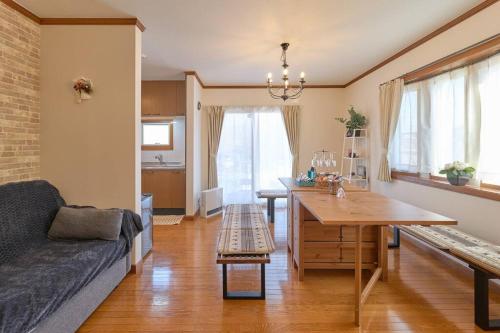 Una sala de estar con un sofá y una mesa de comedor. en 1棟貸切BBQ可 本格ダーツ かき氷機 Villa上条, en Kasugai