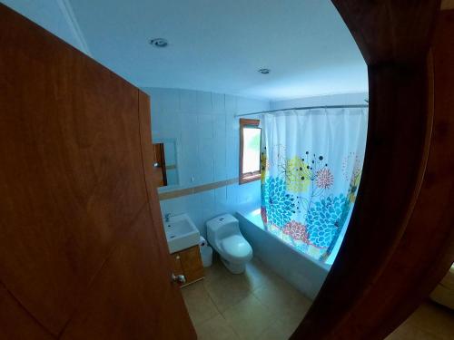 a bathroom with a fish themed shower curtain and a toilet at Cabañas Privadas en Pucon in Pucón