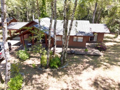 una casa en el bosque con un coche aparcado delante en Cabañas en Pucón, en Pucón
