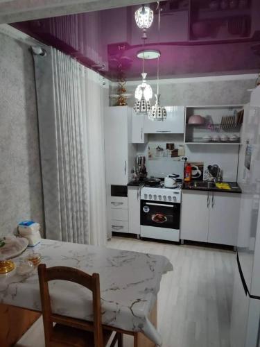 卡拉科爾的住宿－Erkina's - Beautiful Condo in downtown，厨房配有桌子和紫色天花板