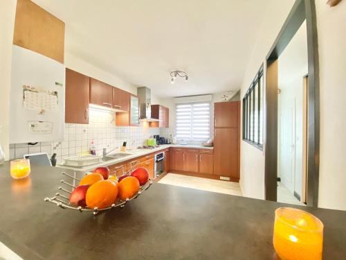 a kitchen with a bowl of fruit on a counter at LA REUNION - Maison - Jardin Clos - Wifi in Ergué-Gabéric