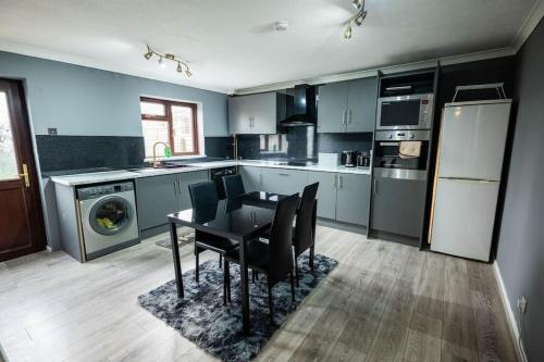 a kitchen with a table and chairs in it at Alaya's Homes 4 bedroom house in Pitsea