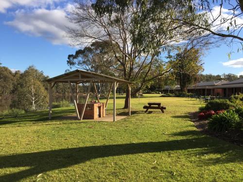 a picnic shelter and a picnic table in a park at Cadell On The Murray Motel in Moama