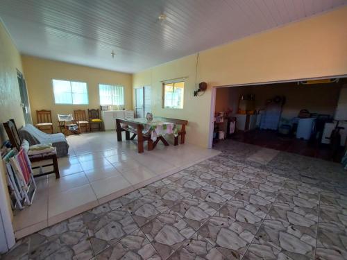 sala de estar con suelo de piedra y mesa en Cheiro de mar en Imbé