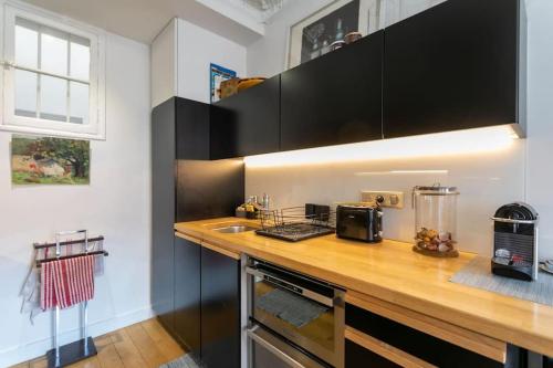 une cuisine avec un comptoir en bois et un évier dans l'établissement Amazing flat Jardin du Luxembourg, à Paris