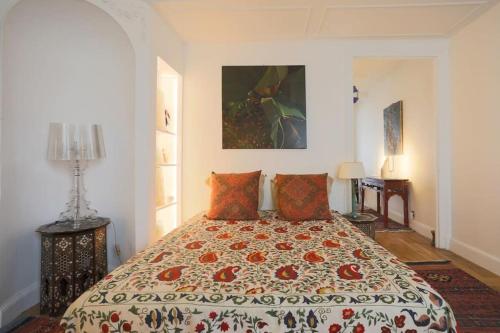 sypialnia z łóżkiem z kołdrą w obiekcie Amazing flat Jardin du Luxembourg w Paryżu