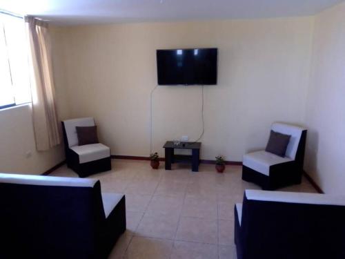 sala de estar con 2 sillas y TV de pantalla plana en Departamento con Hermosa Vista en Yanahuara