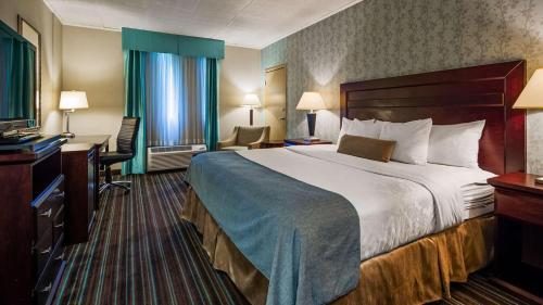 Lockport Hotel في لوكبورت: غرفه فندقيه سرير كبير وتلفزيون