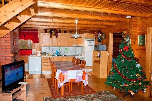 Ferienhaus in Kouvola mit Terrasse und Grill في كووفولا: شجرة عيد الميلاد في مطبخ مع طاولة طعام