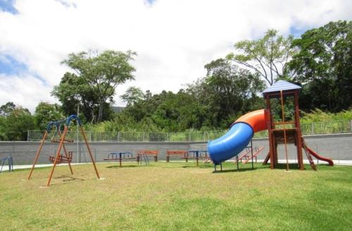 a playground with a slide and other play equipment at Apartamento na Palhoça, com vista para o mar, próximo a mercados, padarias e farmácias. in Palhoça