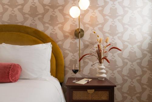 a bedroom with a bed and a vase of flowers on a table at Petit Soleil - Bed, Breakfast and Bar in San Luis Obispo