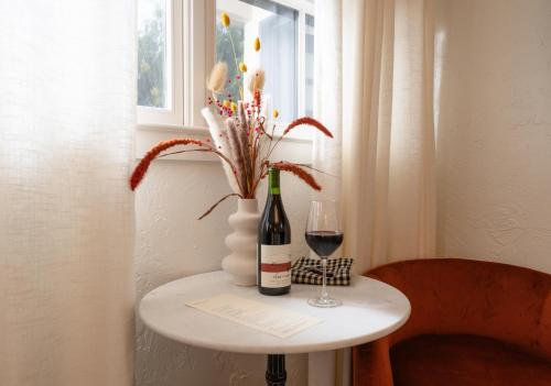 a table with a bottle of wine and a glass at Petit Soleil - Bed, Breakfast and Bar in San Luis Obispo