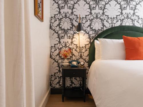 a bedroom with a bed and a black and white wallpaper at Petit Soleil - Bed, Breakfast and Bar in San Luis Obispo