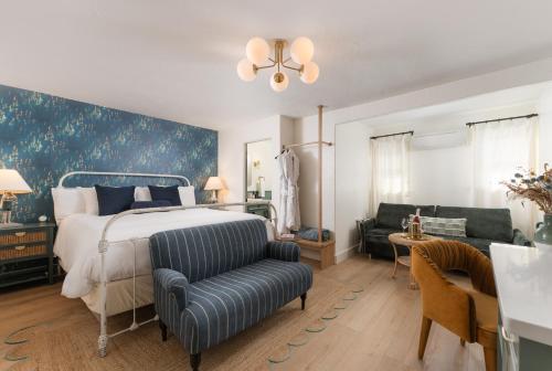 1 dormitorio con 1 cama y 1 sofá en Petit Soleil - Bed, Breakfast and Bar, en San Luis Obispo