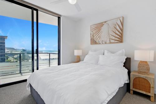 a bedroom with a white bed and a large window at 2BR Luxury Central Palm Beach Apartment (Best Location!) in Gold Coast