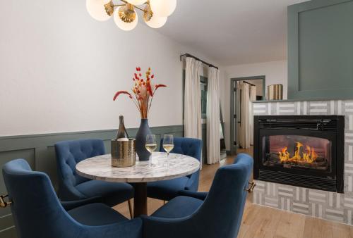 a dining room with a table and chairs and a fireplace at Petit Soleil - Bed, Breakfast and Bar in San Luis Obispo