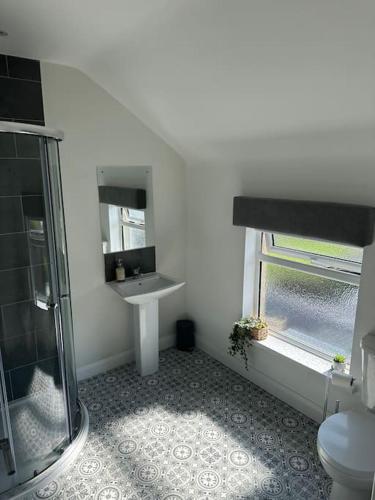 a bathroom with a glass shower and a sink at Westland Suites - Stylish, Modern, Elegant, Central Apartments in Londonderry County Borough