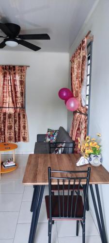 Cozy Apartements في باراماريبو: غرفة طعام بها طاولة ومروحة سقف