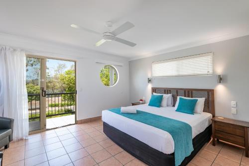 a bedroom with a bed and a balcony at Anchor Motel Noosa in Noosaville