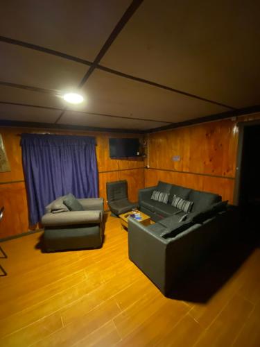 a living room with two couches and a tv at Cabaña Santa Lucía 1 in Villa Santa Lucía