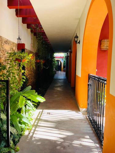 an alley way with an orange and white building at Casa Tres Colibries in Mérida