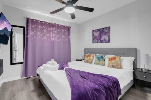 two beds in a bedroom with purple curtains at Big Group, Remodeled, Landscaped, King Beds, Desks in Las Vegas