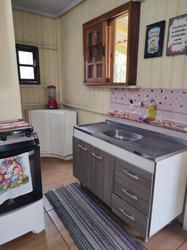 una cucina con lavandino e piano cottura di Casinha paz e descanso a Balneário Gaivotas