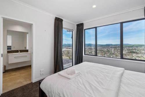 - une chambre avec un lit blanc et une grande fenêtre dans l'établissement The Lookout, à Rotorua