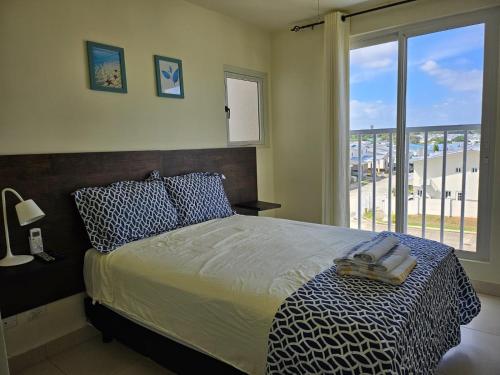 1 dormitorio con cama y ventana grande en Vista al mar 303 en Arraiján