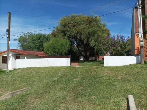 une cour avec une clôture blanche et un arbre dans l'établissement Casa Costa Azul - La Paloma - Rocha - Uruguay, à Costa Azul