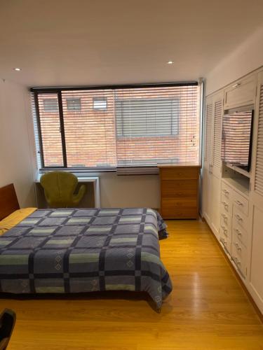 sypialnia z łóżkiem i dwoma dużymi oknami w obiekcie Apartaestudio 95 w mieście Bogota