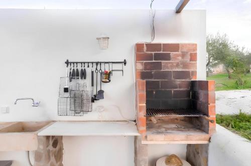 a kitchen with a brick fireplace and a stove at Monte Machial in Alvega