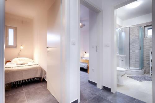 a bedroom with a bed and a bathroom with a toilet at Apartments and rooms by the sea Komiza, Vis - 9722 in Komiža