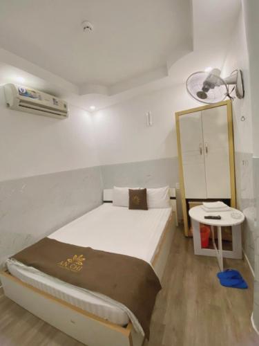 a small bedroom with a bed and a table at Khách sạn An Chi in Ho Chi Minh City