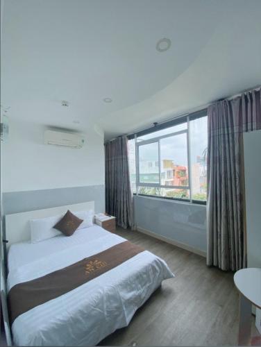 a bedroom with a bed and a large window at Khách sạn An Chi in Ho Chi Minh City