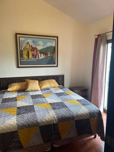 a bedroom with a bed with a checkered blanket at Acogedora casa con firepit in San Juan Obispo