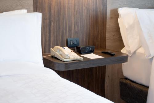 a hotel room with a phone next to a bed at Holiday Inn Express Mexico City Satelite by IHG in Mexico City