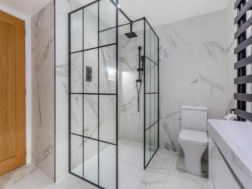 a bathroom with a shower with a glass door at Vectis Cottage in Inverness