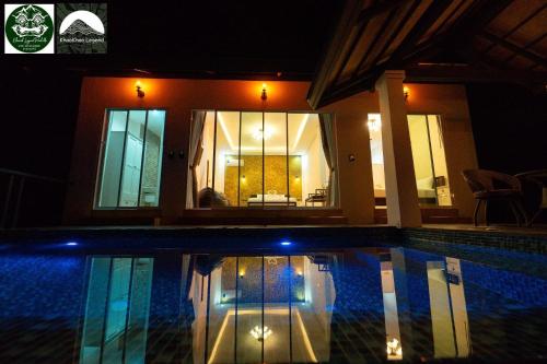 una piscina frente a una casa por la noche en Khaosok legend en Khao Sok