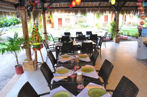een restaurant met tafels en stoelen in een kamer bij SLAM'S Garden Dive Resort in Malapascua Island