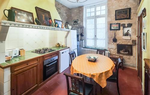 une cuisine avec une table et une cuisinière dans l'établissement Awesome Apartment In Béziers With Wifi, à Béziers